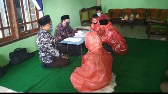 印尼一对新人新冠肺炎疫情期间穿塑料雨衣结婚